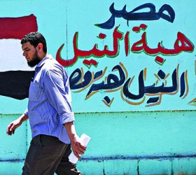A man walks in front of graffiti in Cairo