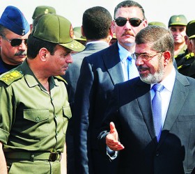File photo of Egypt's President Mohamed Mursi speaking with Defence Minister Sisi during his visit to the 6th Armoured Division of the Second Army, near Ismailia