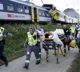 Swiss rescue workers wheel a wounded person on a stretcher after two regional trains crashed head on near Granges-Pres-Marnand near Payerne
