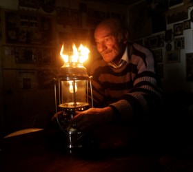 Ο κύριος Κώστας, 75 ετών, προσπαθεί να φωτίσει το σπίτι όπου ζει στο Πέραμα με μία λάμπα πετρελαίου. Ο κύριος Κώστας, οι δύο άνεργοι γιοί του και τα εγγόνια του μένουν σε μία παράγκα στην οποία η ΔΕΗ έχει κόψει την ηλεκτροδότηση, εξαιτίας των απλήρωτων λογαριασμών και τα βγάζουν πέρα με τη βοήθεια της κοινωνικής υπηρεσίας του δήμου. Στο Πέραμα υπάρχουν περίπου 1.000 νοικοκυριά στα οποία η ΔΕΗ έχει διακόψει την ηλεκτροδότηση εξαιτίας των ανείσπρακτων λογαριασμών.