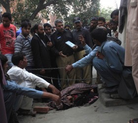 Police collect evidence near body of Farzana Iqbal, killed by family members, at site near Lahore High Court building in Lahore