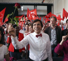 Belgian Prime Minister Di Rupo holding up a rose, chants with party members Laanan and Belgian Social Affairs and Health Minister Onkelinx at a congress of Francophone Socialist party in Brussels