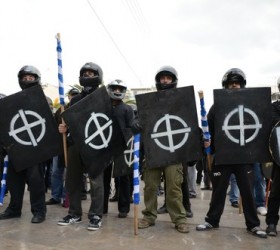 Ο εξοπλισμός με κοντάρια (με το πρόσχημα της σημαίας) και με ασπίδες. Η κάλυψη των προσώπων με κουκούλες και κράνη.