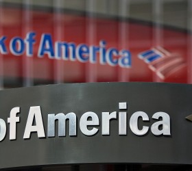 A Bank of America logo hangs above a bank branch entrance in