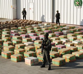 Colombian anti-drugs policemen guard stacks of marijuana seized from the rural area of El Jagual at a military police base in Popayan
