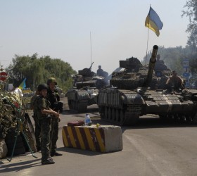 Ukrainian army tanks move past a checkpoint as they patrol area near eastern Ukrainian town of Debaltseve