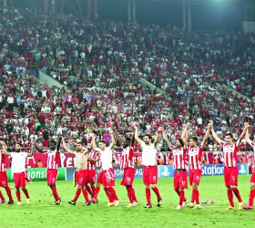 Olympiakos players celebrate after their victory in their Champions League soccer match against Atletico Madrid at Karaiskaki stadium in Piraeus, near Athens