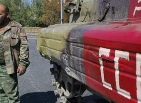 Ενοπλος αυτονομιστής στέκεται πλάι σε ένα τεθωρακισμένο βαμμένο κόκκινο στο οποίο έχει ζωγραφιστεί ένα σφυροδρέπανο και τα αρχικά της ΕΣΣΔ στο Ντόνετσκ

REUTERS/Maxim Shemetov