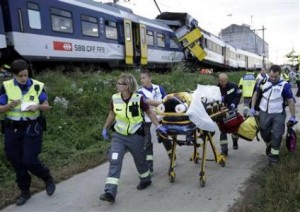 Swiss rescue workers wheel a wounded person on a stretcher after two regional trains crashed head on near Granges-Pres-Marnand near Payerne