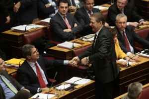Ο Α. Λοβέρδος σφίγγει το χέρι του Β. Πολύδωρα μετά την ομιλία με την οποία κατακεραύνωσε τον νέο φόρο ακινήτων καταχειροκροτούμενος από βουλευτές της αντιπολίτευσης.