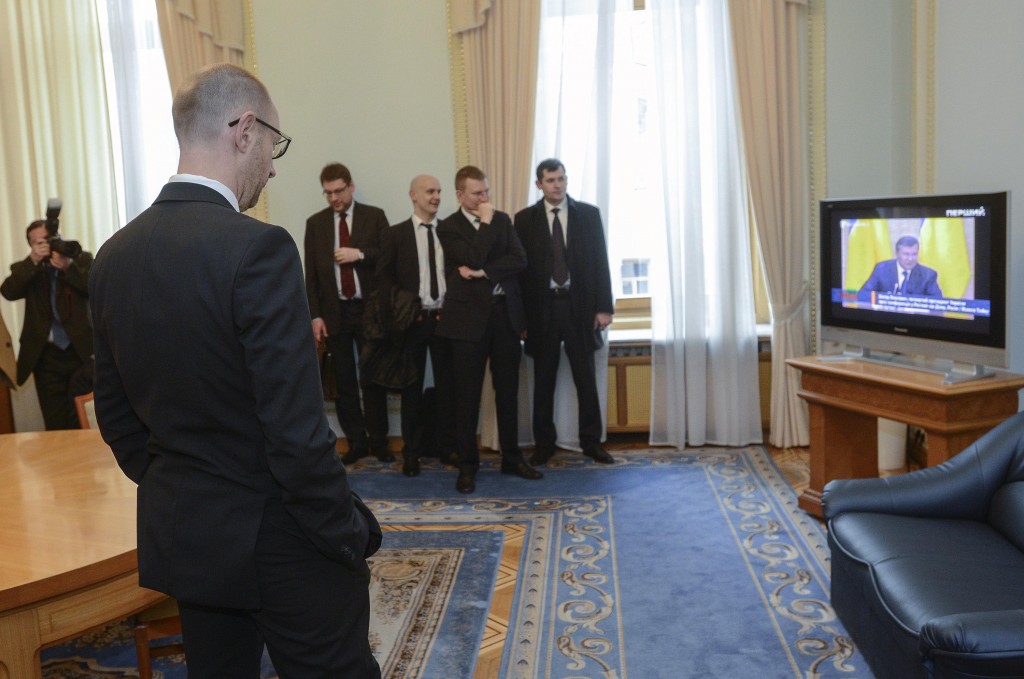 Yatsenyuk, a member of Ukraine's interim leadership, watches a news conference of former Ukranian leader Yanukovich on a screen at the parliament building in Kiev
