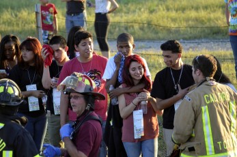 Survivors wait to be transported at the scene of a collision of a tractor-trailer and a tour bus on Interstate 5 near Highway 32 near Orland, California