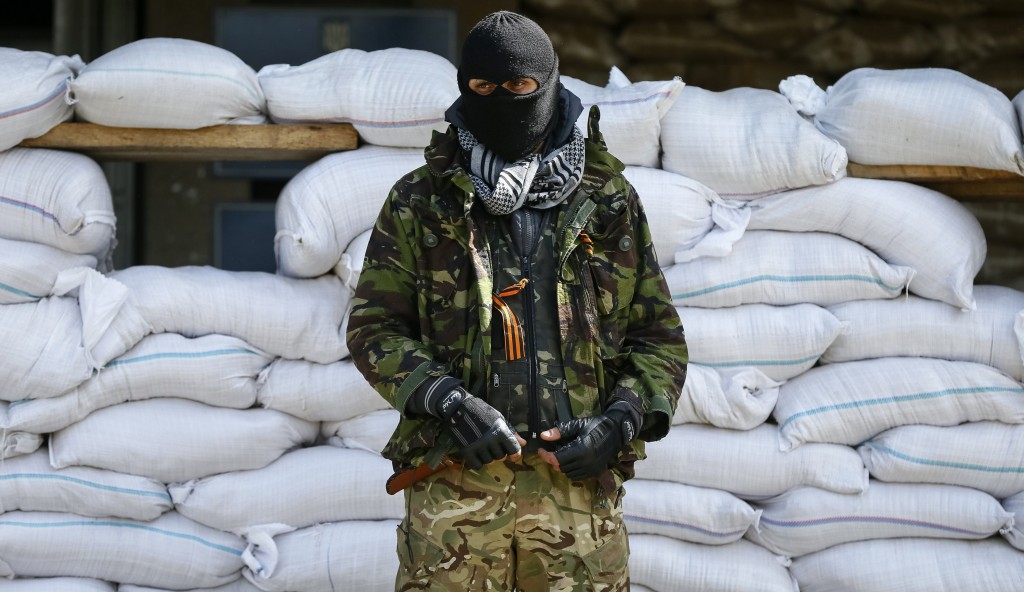 An armed man stands guard in front of barricades outside the mayor's office in Slaviansk