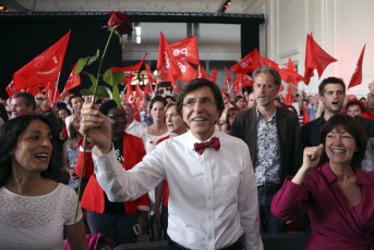 Belgian Prime Minister Di Rupo holding up a rose, chants with party members Laanan and Belgian Social Affairs and Health Minister Onkelinx at a congress of Francophone Socialist party in Brussels