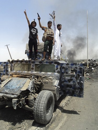  Οπλισμένοι σουνίτες ισλαμιστές πανηγυρίζουν πάνω σε ένα κατεστραμμένο θωρακισμένο Hummer των ιρακινών δυνάμεων ασφαλείας  REUTERS