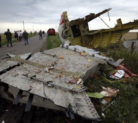 People stand near part of the wreckage of a Malaysia Airlines Boeing 777 plane after it crashed near the settlement of Grabovo in the Donetsk region