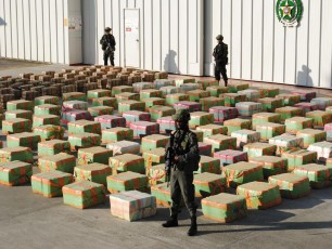 Colombian anti-drugs policemen guard stacks of marijuana seized from the rural area of El Jagual at a military police base in Popayan