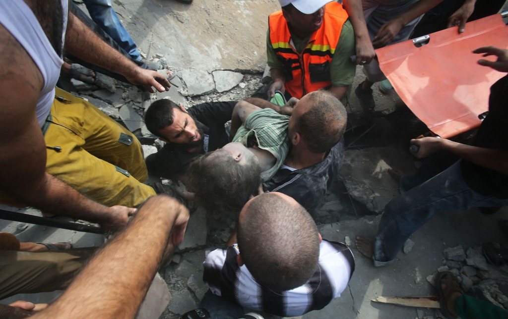 Palestinians remove the body of a boy in Khan Younis in the southern Gaza Strip