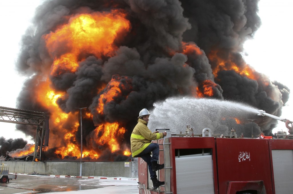 A Palestinian firefighter works during efforts to extinguish a fire at Gaza's main power plant, which witnesses said was hit in Israeli shelling, in the central Gaza Strip