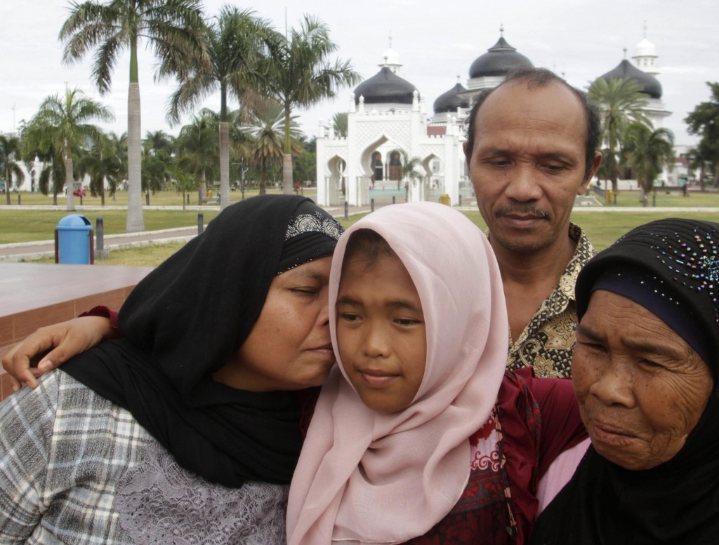 Jamaliah kisses her daughter Jannah, following prayers at Baiturrahman mosque in Banda Aceh