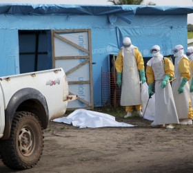Health workers, wearing head-to-toe protective gear, prepare for work, outside an isolation unit in Foya District, Lofa County in this handout photo