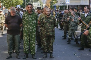 Οι ρωσόφωνοι στρατιώτες του αποσχιστικού στρατού, από την άλλη, δεν έχουν τόσο λαμπερές στολές, μπορούν όμως να προσθέσουν το δικό τους λιθαράκι στην μιλιταριστική βαρβαρότητα, περιφέροντας στον δρόμο αιχμάλωτους πολέμου, κατά το πρότυπο των ρωμαϊκών αυτοκρατορικών θριάμβων REUTERS/Maxim Shemetov 