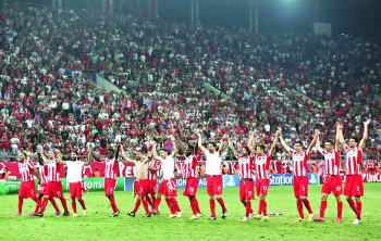 Olympiakos players celebrate after their victory in their Champions League soccer match against Atletico Madrid at Karaiskaki stadium in Piraeus, near Athens