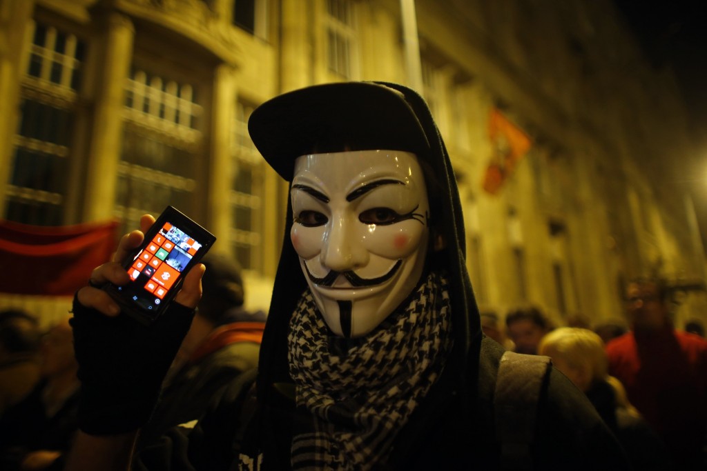 A protester holds his mobile phone during a protest against new tax on Internet data transfers in centre of Budapest